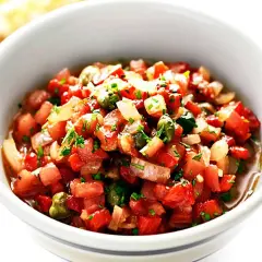 En skål med färsk salsa, perfekt för ditt salsa recept. Tomater, lök och örter blandas till en läcker röra.