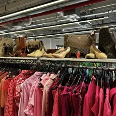 Półka pełna torebek i butów, a pod nią rząd różowych ubrań. Idealne miejsce na przerabianie ubrań i tworzenie nowych stylizacji.