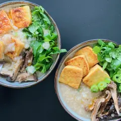 Dwie miseczki aromatycznego congee z chrupiącym tofu, grzybami i świeżymi ziołami.