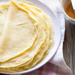 Piatto di crepes dorate, pronte per essere farcite. La ricetta crepes per 4 persone è facile e veloce.