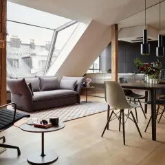 Modernes Wohnzimmer mit Dachfenster: Hier lässt sich Sofa und Esstisch gut kombinieren. Graues Sofa, Holzboden, schwarzer Esstisch mit Stühlen.