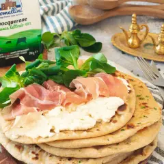Piadina con squacquerone, prosciutto crudo e insalatina. Un classico degli abbinamenti perfetti per un pasto veloce e gustoso.