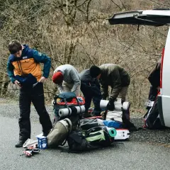 Grupa przygotowuje się do wyprawy w Tatry Wysokie, pakując sprzęt przy samochodzie.
