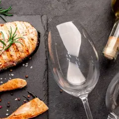 Gegrillter Lachs mit Rosmarin und Pfefferkörnern, bereit für die perfekte Weinbegleitung. Welcher Wein zu Lachs passt, fragst du dich?
