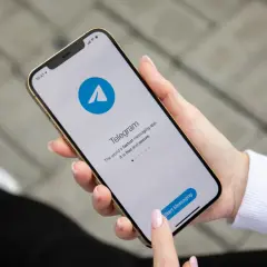 Dłoń trzyma smartfon z otwartą aplikacją Telegram. To szybka i bezpieczna apka do wysyłania wiadomości.