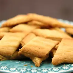 En hög med gyllene kolasnittar med havssalt på en turkosblå tallrik. Perfekt för fikat!