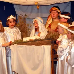 Dzieci odgrywają scenę narodzenia Jezusa, pokazując, skąd się wzięły jasełka.
