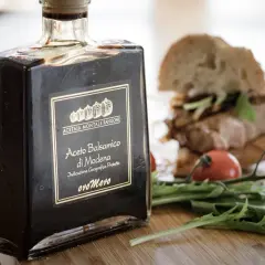 Butelka Aceto Balsamico di Modena, czyli co to jest ocet balsamiczny, obok kanapki i rukoli.