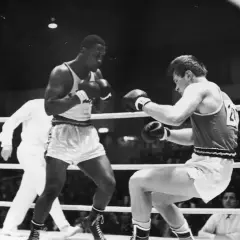 Young Joe Frazier in a boxing match, focused and ready to fight.