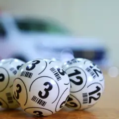 Trzy białe kulki z numerami 3, 8 i 12. Zastanawiasz się, ile idzie przelew z lotto online?