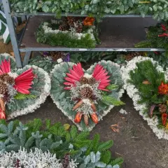 Ekskluzywne sztuczne kwiaty na cmentarz w kształcie serc, ozdobione szyszkami i suszonymi roślinami, tworzą elegancką kompozycję.