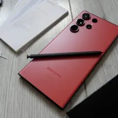 Czerwony Samsung S23 Ultra z rysikiem i akcesoriami. Aparat tego modelu pozwala na robienie niesamowitych zdjęć.