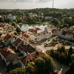 Urokliwe Mrągowo z lotu ptaka. Jezioro, kolorowe kamienice i zielone dachy tworzą malowniczy krajobraz. Odkryj mrągowo atrakcje!