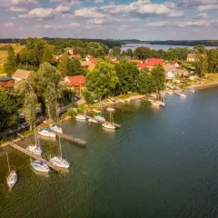 Malowniczy widok na przystań żaglową w Drawskim Parku Krajobrazowym. Woda, łodzie i zielone otoczenie tworzą sielski obraz.