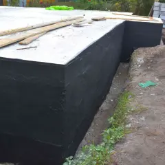 Zakończono hydroizolację piwnicy od zewnątrz. Czarna masa chroni fundamenty przed wilgocią.