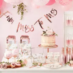 Uroczy stół na wieczór panieński: tort, babeczki, balony, girlanda "From Miss To Mrs" i kieliszki z różowym napojem.