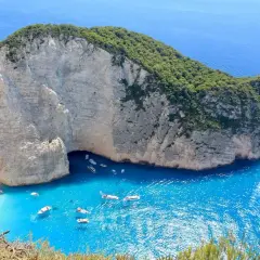 Widok na Navagio Beach na Zakynthos. Turkusowa woda, białe klify i łodzie. Zastanawiasz się, ile się leci na Zakynthos?