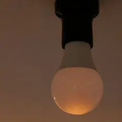 Żarówka LED, mimo że wyłączona, delikatnie żarzy się, budząc pytanie: dlaczego żarówka świeci po wyłączeniu?