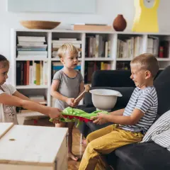 Dzieci szarpią się o zieloną zabawkę, widać kłótnie przy dziecku.