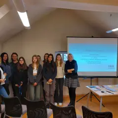 Grupa osób na tle ekranu projekcyjnego w Miejskim Ośrodku Pomocy Społecznej w Lublińcu.
