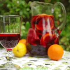 Orzeźwiająca sangria wino z owocami w dzbanku i kieliszku, obok pomarańcze i cytryna. Idealna na letnie popołudnie.