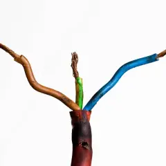 Beschädigte Kabel mit freiliegenden Drähten, die auf einen möglichen kabelbrand geruch hindeuten. Die Isolierung ist an einer Stelle geschmolzen.