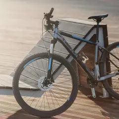 Szary rower crossowy z niebieskimi akcentami, idealny na wycieczki i do jazdy po trudniejszym terenie. Ten rower mtb czeka na przygodę.