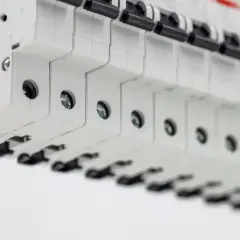 Szczegółowy widok bezpieczników w rozdzielnicy. Zbliżenie na przewód uziemiający. Określenie koszt instalacji elektrycznej.