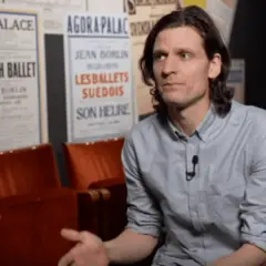 Erik Mattsson vid Dansmuseet, omgiven av affischer för Swedish Ballet och Les Ballets Suédois.