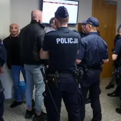 Policjanci otaczają grupę mężczyzn, wśród których mogą być psycho fans. Wszyscy mają zakryte twarze.