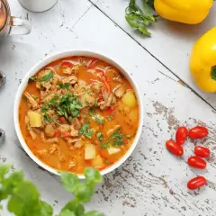 Aromatic gulasz, idealny na dietę trzustkową, z kawałkami mięsa, ziemniaków i papryki, ozdobiony natką pietruszki.