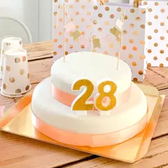 Tort urodzinowy z cyframi 28, ozdoby i prezenty na drewnianym stole.