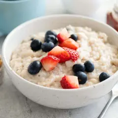 Haferbrei mit Beeren und Nüssen. Bei Darmentzündung was essen? Leichte Kost wie dieser Brei ist gut verträglich.