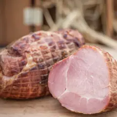 Wędzonka po peklowaniu na sucho próżniowo. Jedna sztuka przekrojona, ukazująca soczyste, różowe mięso.