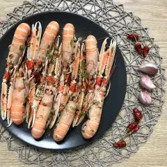 Plato de cigalas al ajillo, con guindillas y ajos.
