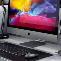Elegancka podstawka pod słuchawki obok komputera iMac.