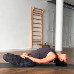 Mujer en postura de yoga Matsyasana, disfrutando de la apertura de pecho yoga beneficios.