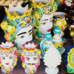 Ceramiche siciliane con teste di moro, vasi decorati e piatti colorati, un'esplosione di arte che ricorda il fascino di Palermo.