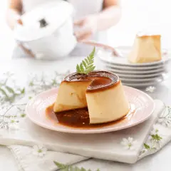 Delicioso flan de queso con caramelo líquido, decorado con una ramita verde.
