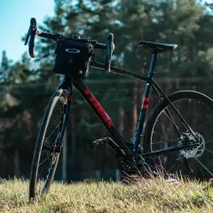 Czarny rower gravelowy z sakiewką na kierownicy, gotowy na wyprawę wzdłuż rzeki Loary.
