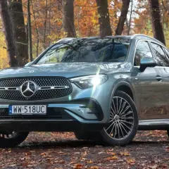 Szary Mercedes GLC 300 4Matic na tle jesiennego lasu.