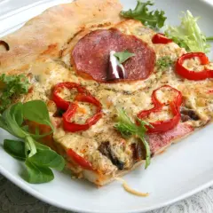 Proste ciasto na pizzę zawsze wychodzi, oto kawałek z salami, papryką i serem, udekorowany świeżą sałatką.