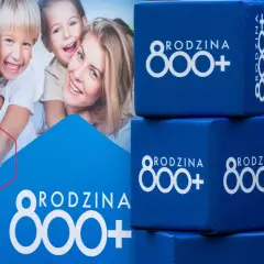 Uśmiechnięta rodzina na plakacie i niebieskie kostki z napisem "RODZINA 800+". Wniosek ZUS o świadczenie 800 plus to wsparcie dla rodzin.