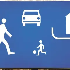 Znak informuje o przepisach dla drogi wewnętrznej: piesi, samochody i plac zabaw.