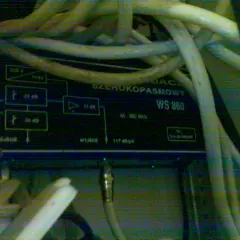 Wzmacniacz sygnału telewizji kablowej w bloku, model WS 860, z licznymi kablami.
