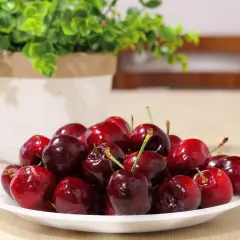 Talerz pełen lśniących czereśni, które kuszą swoim kolorem i smakiem. Warto je jeść dla zdrowia i przyjemności!