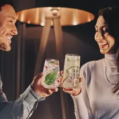 Para wznosi toast drinkami, szukając inspiracji na białystok atrakcje dla par.