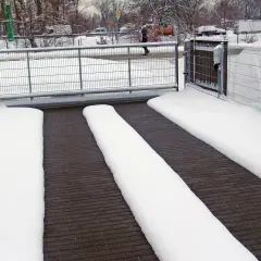 Śnieg pokrywa podjazd, ale dzięki systemowi podgrzewania, ścieżki dla samochodów pozostają czyste.
