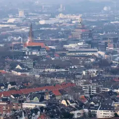 Rozległy krajobraz miejski, gdzie widać charakterystyczne budynki i dachy, tworzy obraz miasta Dortmund.