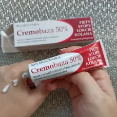 Dłonie aplikują krem Cremobaza 50% na skórę, by wygładzić zrogowacenia na piętach, stopach, łokciach i kolanach.